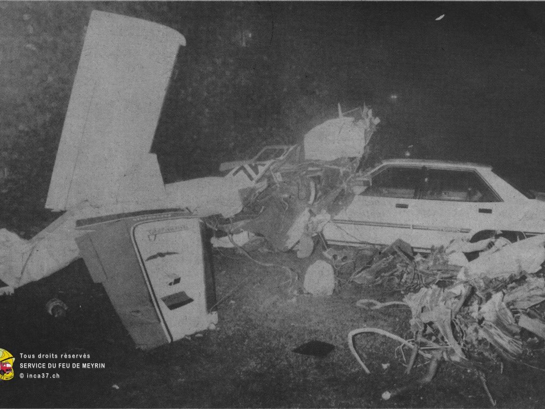 Epave de l'avion parmis les voitures stationnées en bas de l'immeuble.